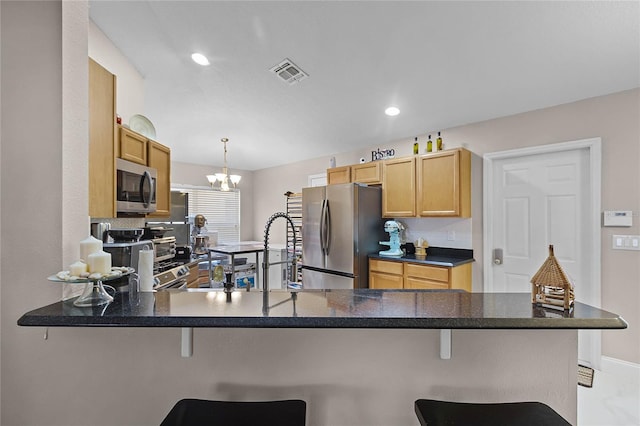 kitchen featuring kitchen peninsula, stainless steel appliances, and a kitchen breakfast bar