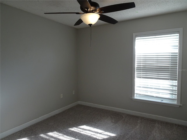 carpeted empty room featuring ceiling fan and a textured ceiling