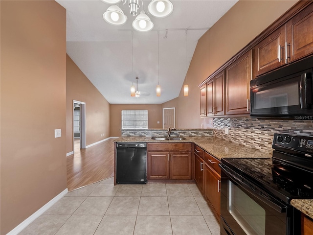 kitchen featuring decorative backsplash, kitchen peninsula, black appliances, sink, and light stone countertops