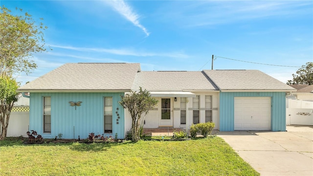 single story home featuring a garage, a front yard, and covered porch