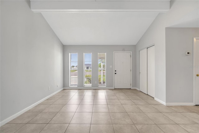 tiled entryway featuring vaulted ceiling with beams