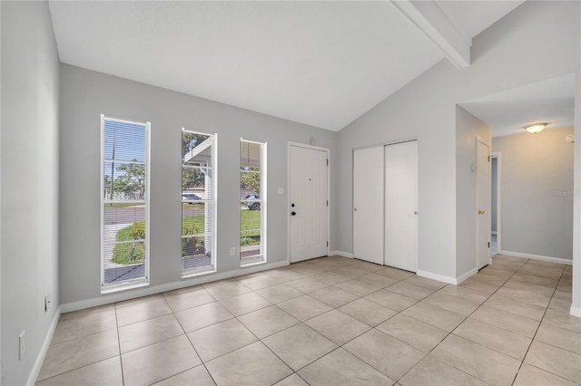 foyer entrance featuring light tile patterned floors and lofted ceiling with beams