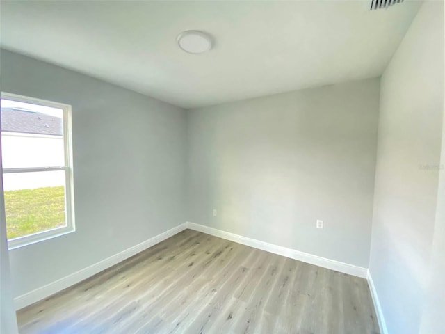 empty room featuring plenty of natural light and light hardwood / wood-style flooring