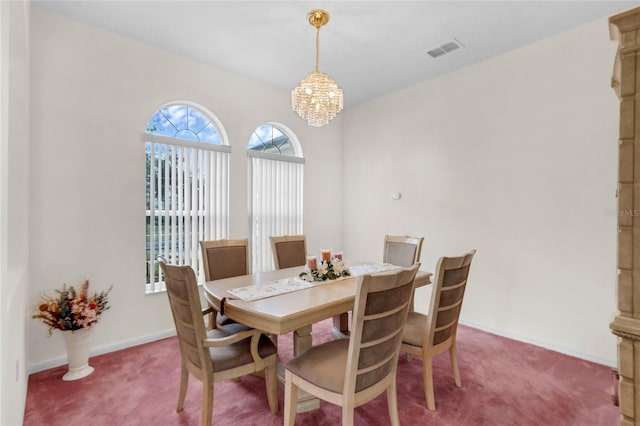 dining space with carpet flooring and a chandelier