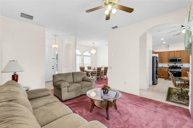 living room featuring ceiling fan with notable chandelier and light tile patterned floors