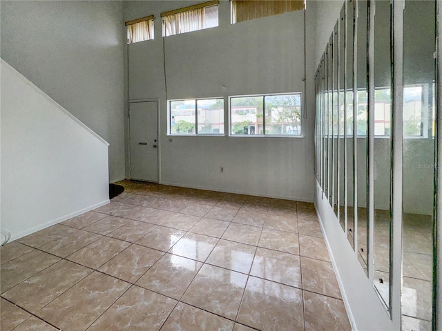 spare room with light tile patterned floors and a high ceiling