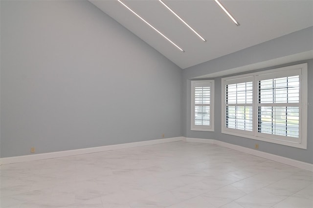 spare room featuring a healthy amount of sunlight and vaulted ceiling