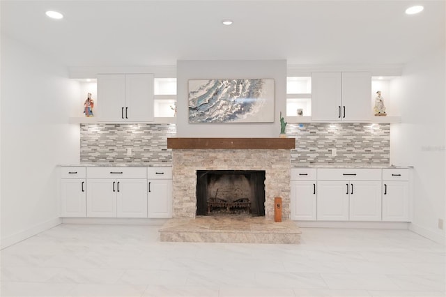 unfurnished living room featuring a stone fireplace