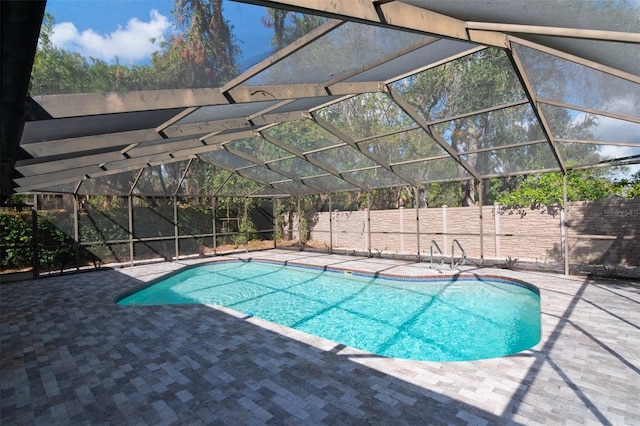 view of swimming pool with glass enclosure and a patio area