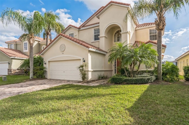 mediterranean / spanish home with a garage and a front yard