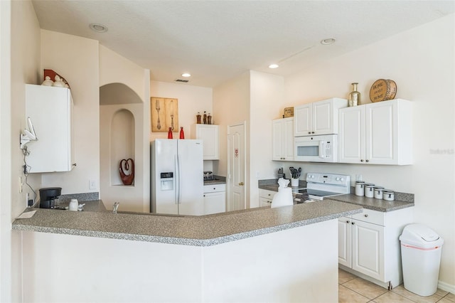 kitchen with kitchen peninsula, a textured ceiling, light tile patterned floors, white appliances, and white cabinets