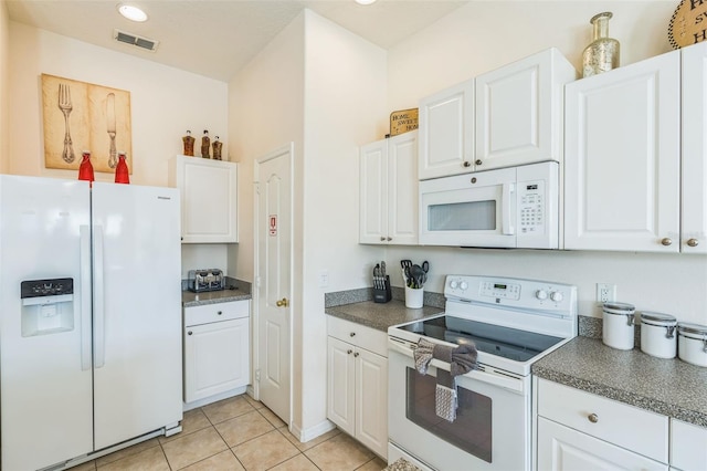 kitchen with white appliances, light tile patterned floors, and white cabinets