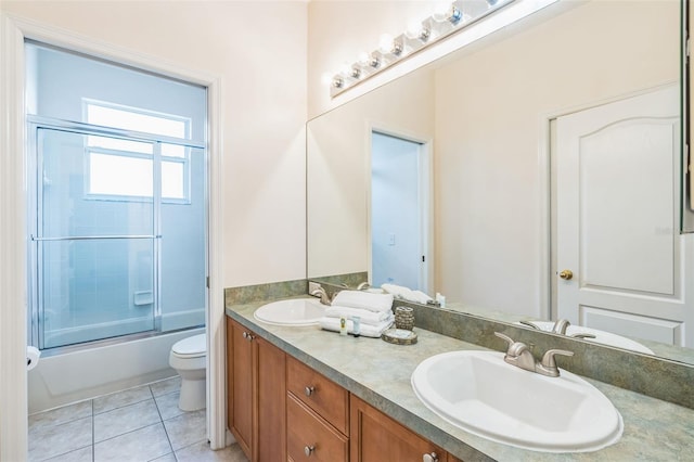 full bathroom featuring toilet, vanity, bath / shower combo with glass door, and tile patterned flooring