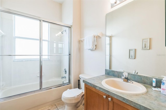 full bathroom with toilet, enclosed tub / shower combo, tile patterned floors, and vanity