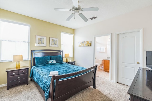 bedroom featuring ensuite bathroom, ceiling fan, and light carpet