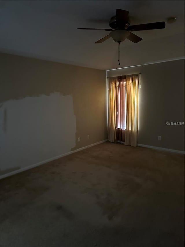 carpeted empty room featuring ceiling fan