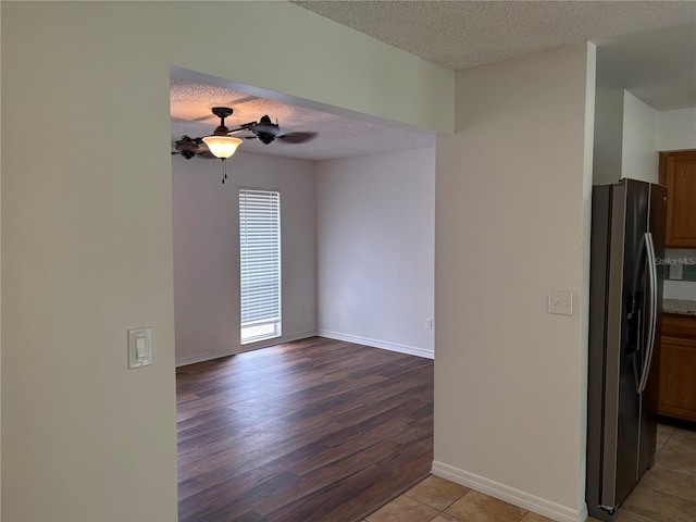 unfurnished room featuring ceiling fan, a textured ceiling, and light wood-type flooring