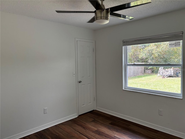 spare room with ceiling fan, a textured ceiling, dark hardwood / wood-style floors, and plenty of natural light