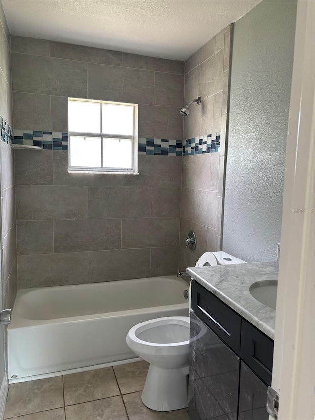 full bathroom featuring tile patterned floors, vanity, a textured ceiling, toilet, and tiled shower / bath