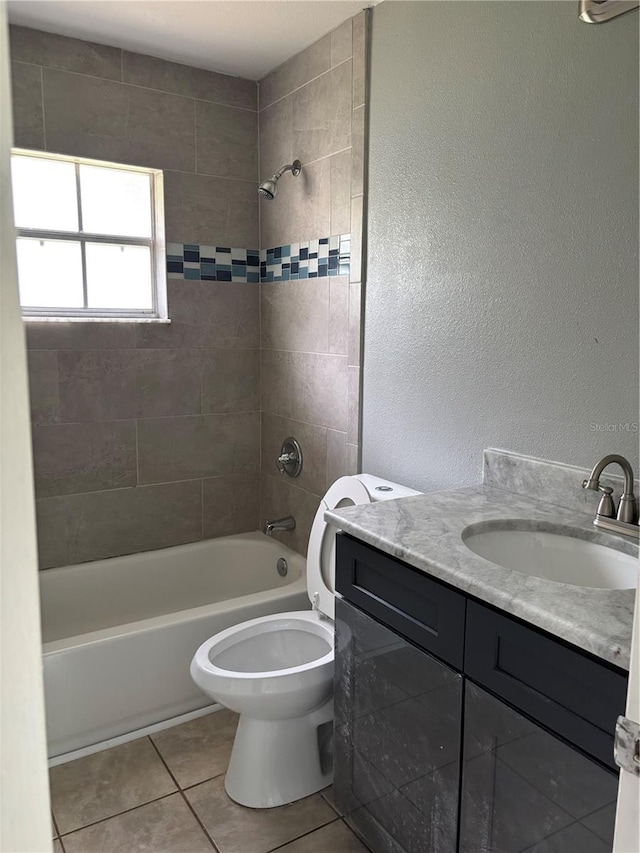 full bathroom featuring toilet, vanity, tiled shower / bath, and tile patterned floors