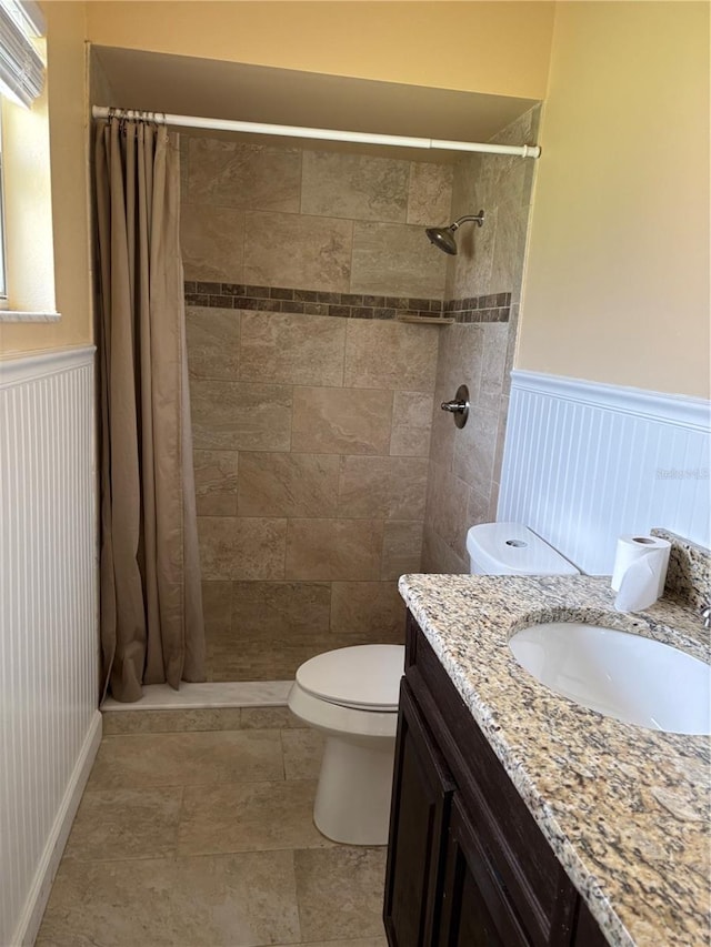 bathroom featuring curtained shower, vanity, and toilet