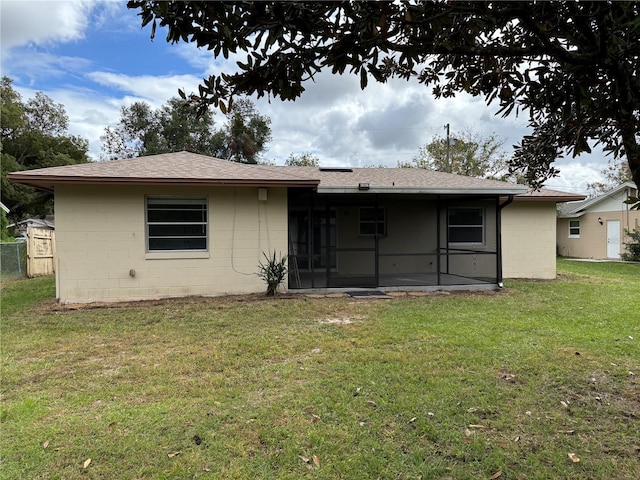 back of property featuring a sunroom and a yard