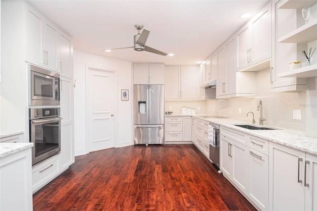 340 S Palm Ave Unit 11, Sarasota, FL 34236 - kitchen with appliances with stainless steel finishes, a ceiling fan, open shelves, dark wood-style flooring, and light stone counters