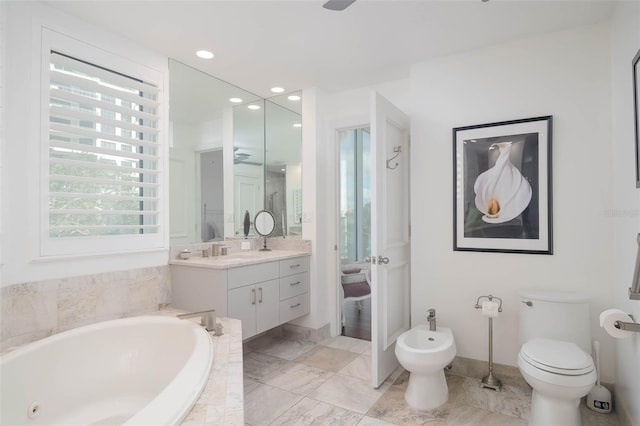 bathroom featuring tiled tub, vanity, and a bidet