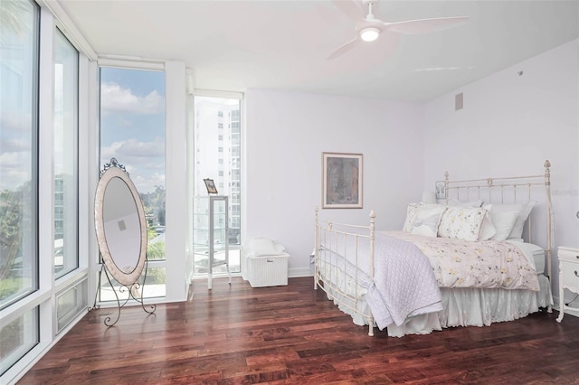 bedroom featuring expansive windows, ceiling fan, and dark wood-type flooring