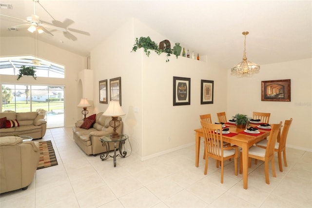 tiled dining space featuring ceiling fan with notable chandelier and vaulted ceiling