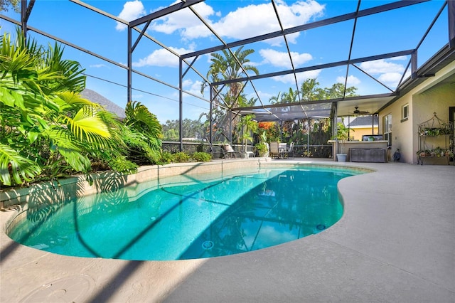 view of swimming pool featuring glass enclosure and a patio area