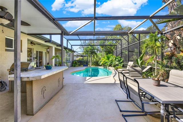 view of swimming pool featuring exterior bar, a patio, grilling area, exterior kitchen, and ceiling fan