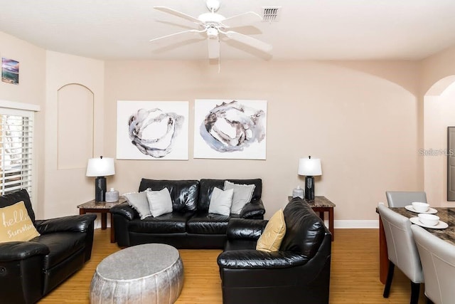 living room with wood-type flooring and ceiling fan