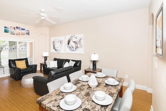 dining space with hardwood / wood-style flooring and ceiling fan