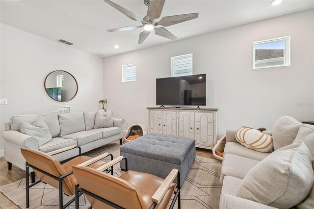 living room featuring a wealth of natural light, ceiling fan, and light hardwood / wood-style flooring