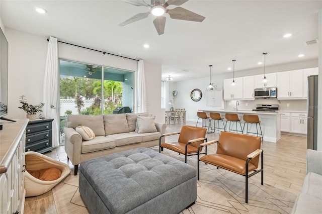 living room featuring ceiling fan and light hardwood / wood-style flooring