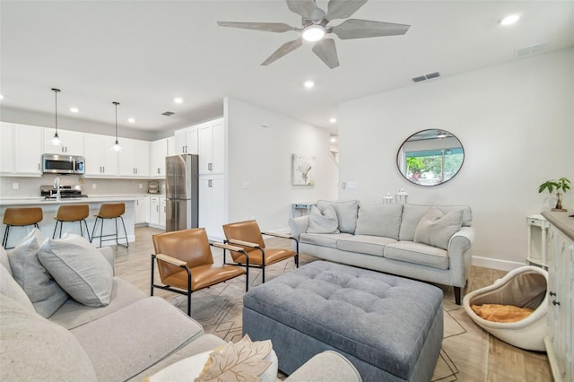 living room featuring light hardwood / wood-style floors and ceiling fan