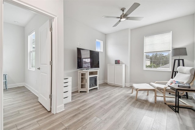 sitting room featuring light wood-type flooring, plenty of natural light, and ceiling fan