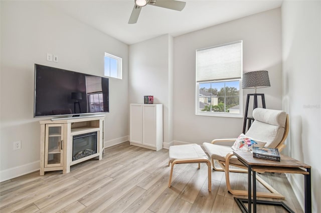 living area with ceiling fan and light hardwood / wood-style floors