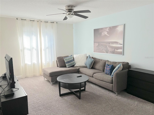 living room featuring carpet, a textured ceiling, and ceiling fan