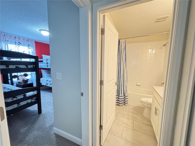 full bathroom with a textured ceiling, shower / tub combo with curtain, vanity, tile patterned floors, and toilet