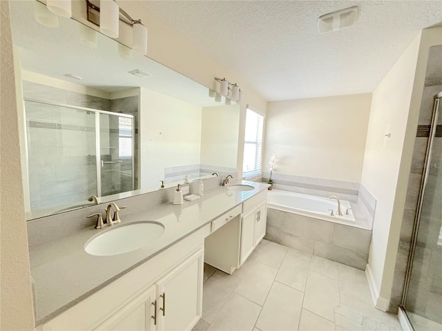 bathroom with tile patterned flooring, vanity, a textured ceiling, and separate shower and tub