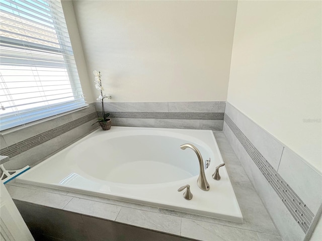 bathroom with a healthy amount of sunlight and tiled tub