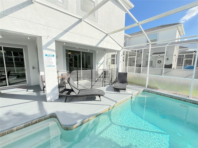 view of swimming pool with glass enclosure and a patio area