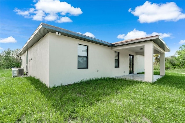 back of property featuring a lawn, central AC, and a patio area