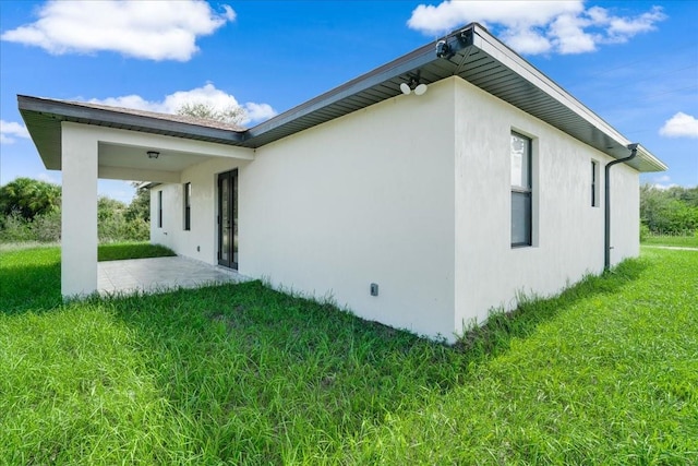 view of side of property with a lawn and a patio