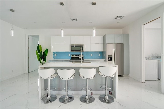 kitchen with white cabinetry, pendant lighting, appliances with stainless steel finishes, and sink