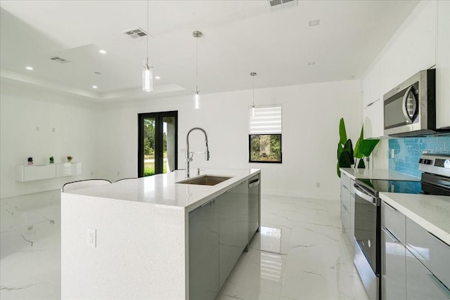 kitchen featuring stainless steel appliances, plenty of natural light, a large island, and decorative light fixtures