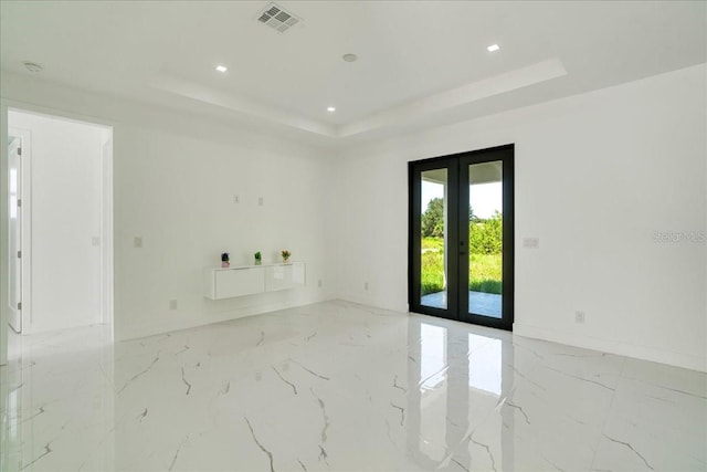 spare room featuring french doors and a tray ceiling