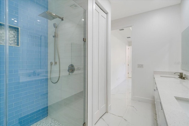 bathroom with vanity and a tile shower